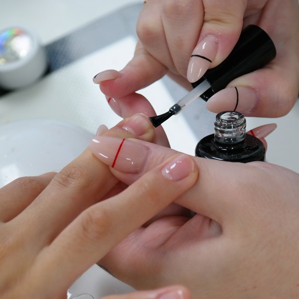 Nail designer fazendo a retirada do esmalte